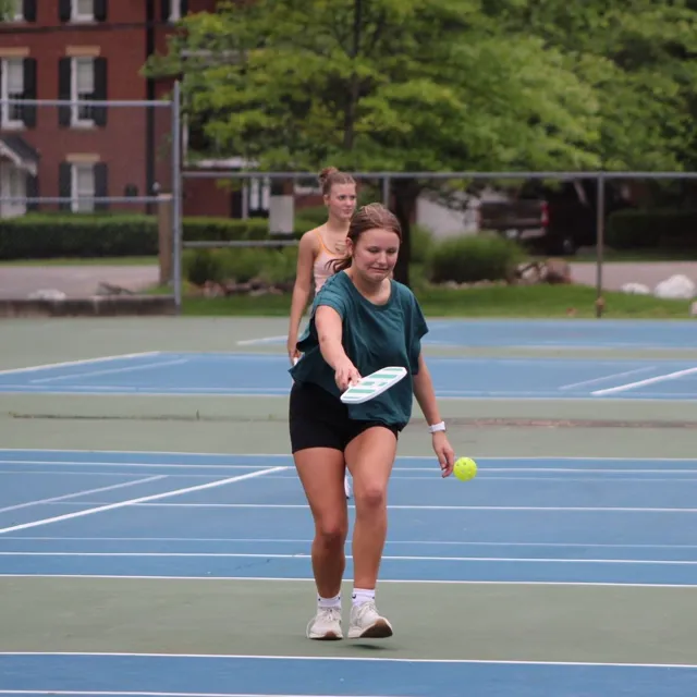 Members playing pickleball on an outdoor court